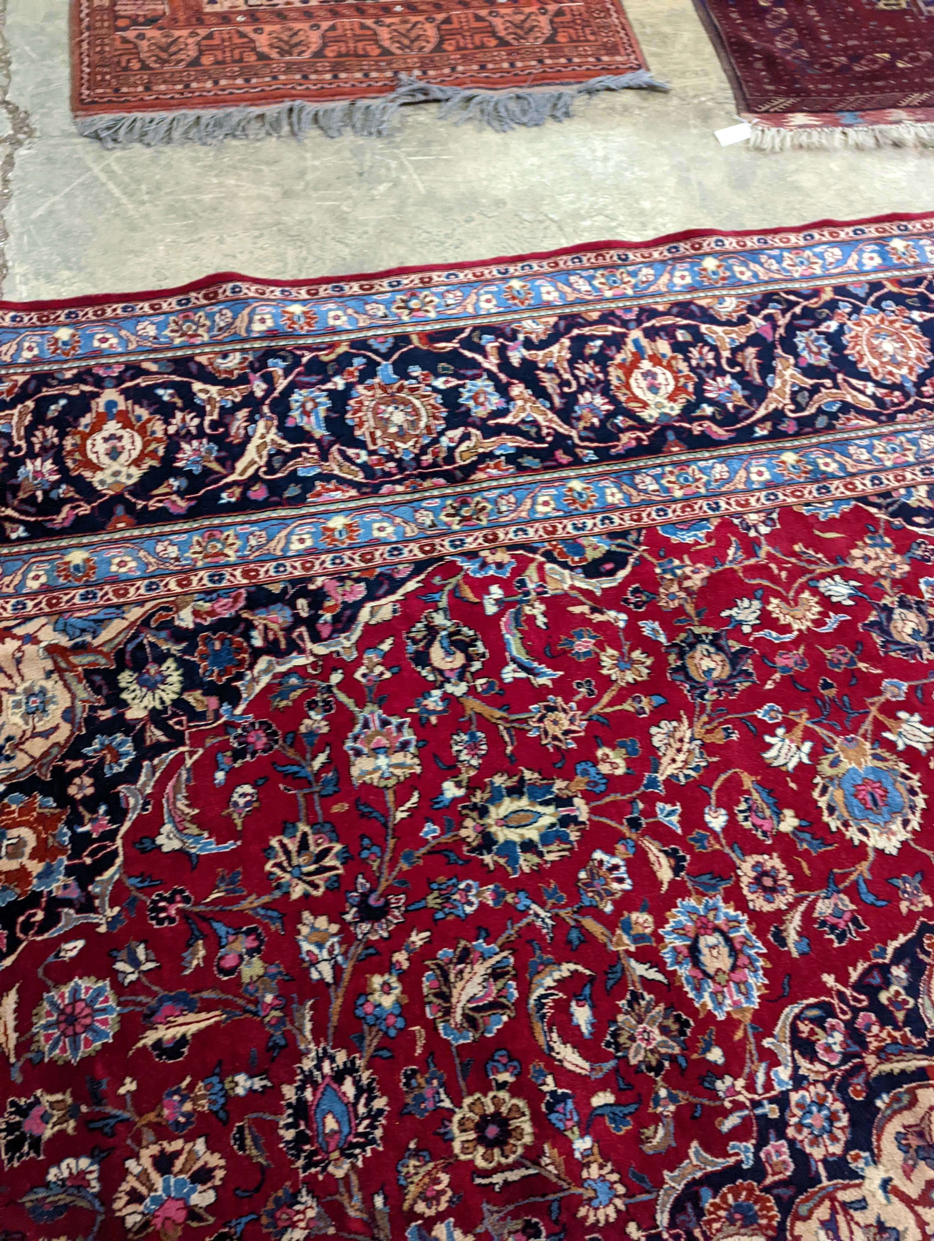 A Kashan burgundy ground carpet, 380 x 300cm